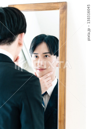 鏡の前で身だしなみを整えるスーツ姿の男性 鏡の前で身だしなみを整えるスーツ姿の男性 138316045
