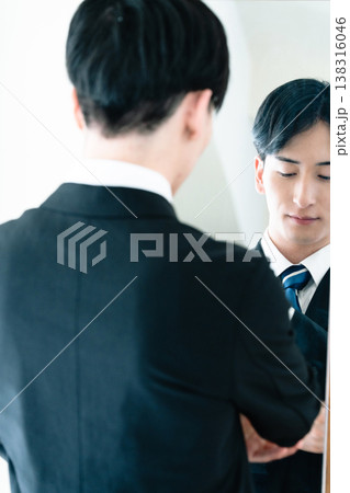 鏡の前で身だしなみを整えるスーツ姿の男性 鏡の前で身だしなみを整えるスーツ姿の男性 138316046
