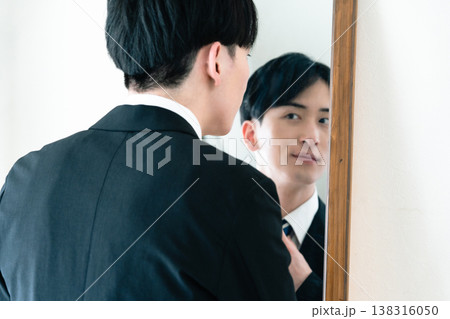 鏡の前で身だしなみを整えるスーツ姿の男性 鏡の前で身だしなみを整えるスーツ姿の男性 138316050