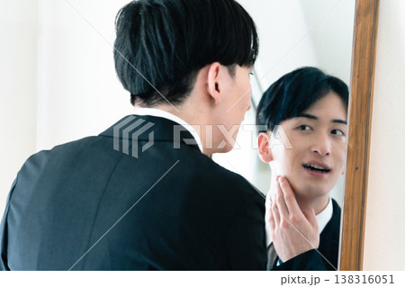 鏡の前で身だしなみを整えるスーツ姿の男性 鏡の前で身だしなみを整えるスーツ姿の男性 138316051