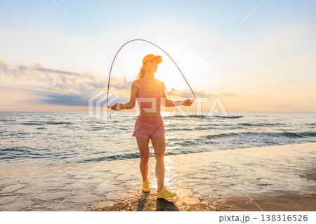 Fit woman jumping rope at the beach during summer vacation 138316526