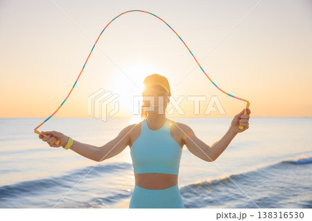 Fit woman jumping rope at the beach during summer vacation 138316530