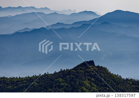 北八ヶ岳・中山展望台から見るにゅうの岩峰と朝もやの西上州の山並み 138317597