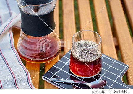 Pour over coffee in ribbed glass on wooden table with carafe Pour over coffee in ribbed glass on wooden table with carafe 138319302