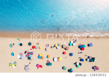 Aerial view of colorful umbrellas on sandy beach, blue sea Aerial view of colorful umbrellas on sandy beach, blue sea 138319531