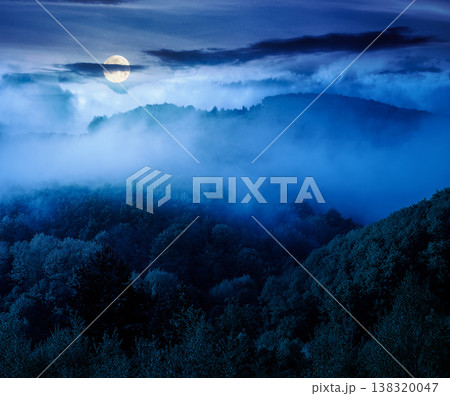 mountain landscape with cold fog at night. low clouds evaporating over the forested hill in full moon light. outdoor scenery in spring for remote highland ecotourism. mysterious greenery fantasy mountain landscape with cold fog at night. low clouds evaporating over the forested hill in full moon light. outdoor scenery in spring for remote highland ecotourism. mysterious greenery fantasy 138320047