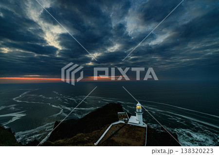 地球岬の暁前 重厚な雲と静かな海に佇む灯台の風景 138320223