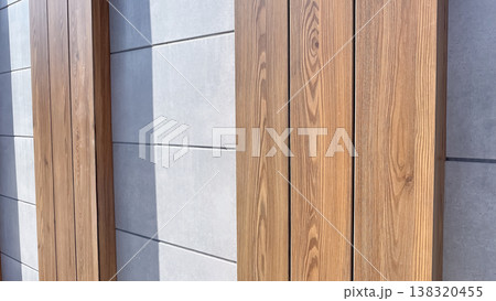Modern architectural background featuring natural wood planks and grey concrete panels with shadows 138320455
