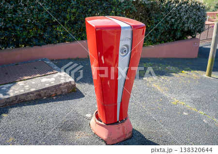Red automatic parking barrier control post on urban street access system security bollard equipment 138320644