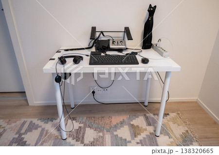 Minimalist home office workspace with computer keyboard headphones and modern desk setup in clean interior style Minimalist home office workspace with computer keyboard headphones and modern desk setup in clean interior style 138320665
