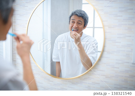 鏡を見ながら歯磨きをする60代男性 鏡を見ながら歯磨きをする60代男性 138321540