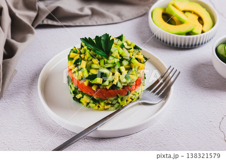Pescetarian salad with lightly salted salmon, cucumber and avocado on a plate on the table Pescetarian salad with lightly salted salmon, cucumber and avocado on a plate on the table 138321579