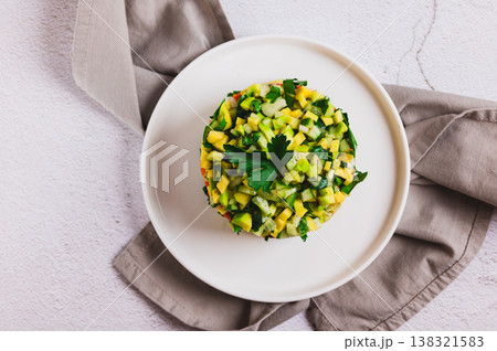 Close up of diet salad with avocado, cucumber and red fish on a plate on the table top view Close up of diet salad with avocado, cucumber and red fish on a plate on the table top view 138321583