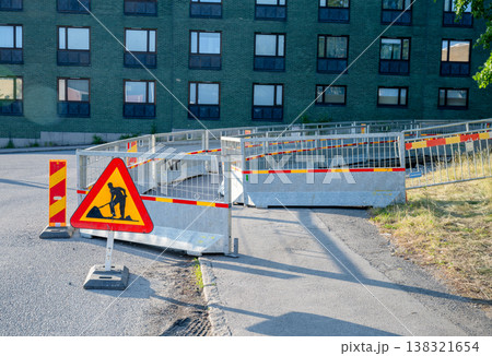 Road construction warning sign with safety barriers urban street repair zone infrastructure work concept Road construction warning sign with safety barriers urban street repair zone infrastructure work concept 138321654