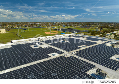 Aerial view of blue photovoltaic solar panels mounted on industrial building roof for producing green ecological electricity. Production of sustainable energy concept 138323203