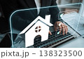 Hand of a Businessperson Using Laptop with Home Symbol to Represent Real Estate Management and Online Property Transactions in a Modern Office Environment Gluon 138323500