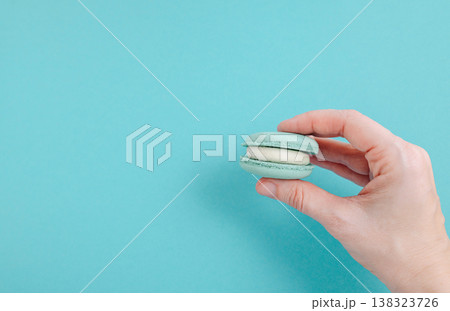 Pair of turquoise macarons on solid turquoise background, teal monochrome food photography for summer concept Pair of turquoise macarons on solid turquoise background, teal monochrome food photography for summer concept 138323726