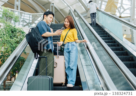 旅先のエスカレーターでスマホを見るカップル　「撮影協力：関西国際空港（KIX）」 138324731