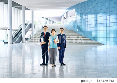 オフィスビルのロビーで笑顔で並ぶビジネスチームの男女 138326148