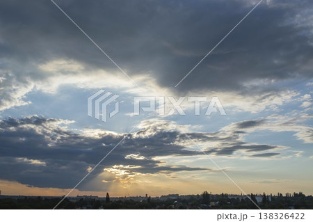 Dramatic sky with sun rays breaking through clouds over cityscape. Sky with sun rays and clouds. Dramatic sky with sun rays breaking through clouds over cityscape. Sky with sun rays and clouds. 138326422