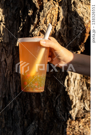 Person holding bubble tea with green boba pearls Person holding bubble tea with green boba pearls 138326551