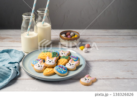 Easter cookies with bottles of milk on white wooden background and mini chocolate easter candy eggs. Spring holidays background 138326826