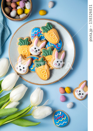 Easter spring holiday background with easter cookies in a plate: bunny, carrot and egg with white tulips Easter spring holiday background with easter cookies in a plate: bunny, carrot and egg with white tulips 138326831