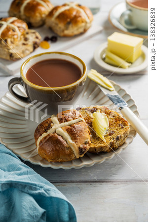 Easter food table setting. Cross Buns with butter, served with tea. Breakfast concept Easter food table setting. Cross Buns with butter, served with tea. Breakfast concept 138326839