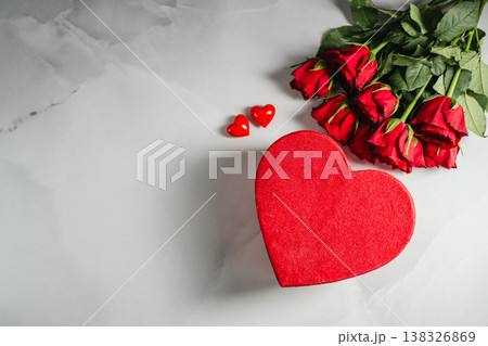 Valentine's Day background. Red roses flowers and heart gift box on bright background. Festive greeting card, flat lay Valentine's Day background. Red roses flowers and heart gift box on bright background. Festive greeting card, flat lay 138326869