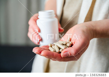 Woman's hand holding a pile of pills and capsules. Prescription medication, treatment sickness concept Woman's hand holding a pile of pills and capsules. Prescription medication, treatment sickness concept 138326883