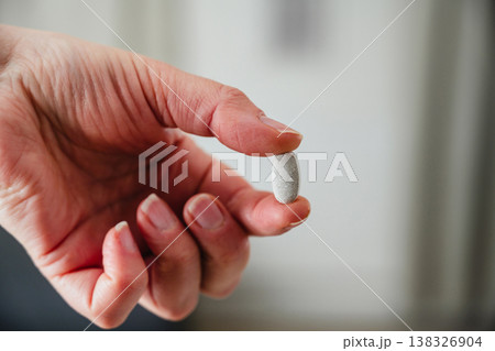 Woman holding a pill in hand. Prescription medication, treatment and sickness concept, seasonal flu and cold Woman holding a pill in hand. Prescription medication, treatment and sickness concept, seasonal flu and cold 138326904