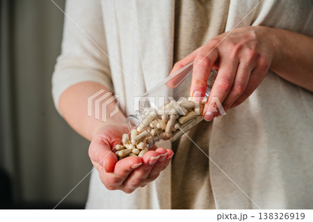 Woman pouring a pile of pills, capsules from bottle in hand. Prescription medication, treatment sickness concept Woman pouring a pile of pills, capsules from bottle in hand. Prescription medication, treatment sickness concept 138326919