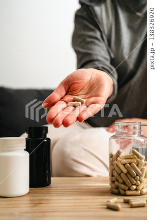 Food supplements and vitamins. Woman holding a pill capsules with pill bottles at home, healthy care concept. Food supplements and vitamins. Woman holding a pill capsules with pill bottles at home, healthy care concept. 138326920