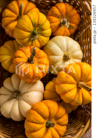 Autumn pumpkins background. Orange and white mini squashes in a basket, rustic style. 138326957