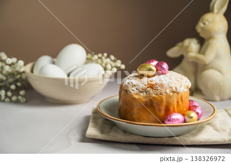 Spring holiday background. Easter Cake with chocolate colorful eggs, gypsophila flowers and cute bunnies 138326972