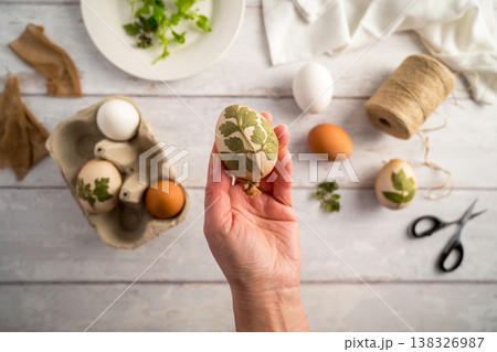 DIY Easter eggs with natural leaves, creating patterns on eggs using plants. Eco friendly colouring easter eggs DIY Easter eggs with natural leaves, creating patterns on eggs using plants. Eco friendly colouring easter eggs 138326987