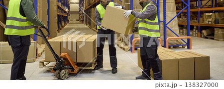 Warehouse workers handling boxes during inventory control with pallet jack Warehouse workers handling boxes during inventory control with pallet jack 138327000