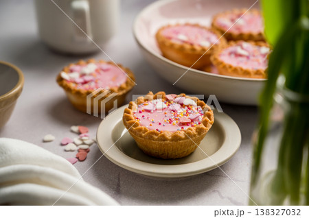 Valentine's day. Pink mini tarts with heart shaped sprinkles and cup of coffee. 138327032