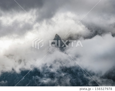 Misty peak rises above swirling clouds Misty peak rises above swirling clouds 138327978