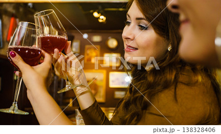 Two friends toasting with wine glasses at pub. 138328406