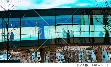 Unrecognizable Shoppers Silhouettes In Glass Mall Corridor With Residential Buildings In Grenoble Unrecognizable Shoppers Silhouettes In Glass Mall Corridor With Residential Buildings In Grenoble 138328924
