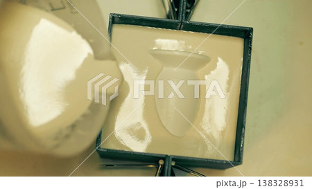 Close up of plaster slip casting mold being made around a master model in a pottery workshop 138328931