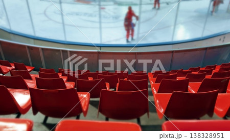 Empty Red Arena Seats Facing Ice Rink During Hockey Training or Match Empty Red Arena Seats Facing Ice Rink During Hockey Training or Match 138328951