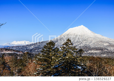 雪化粧の雌阿寒岳と雄阿寒岳 澄んだ青空の山岳風景 雪化粧の雌阿寒岳と雄阿寒岳 澄んだ青空の山岳風景 138329227