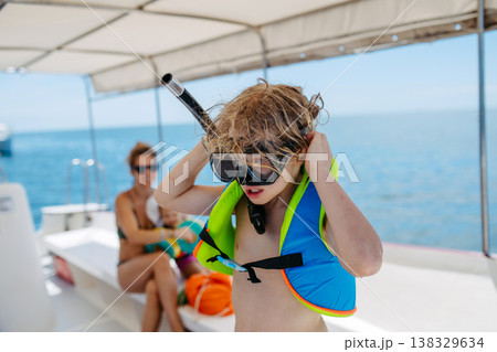 Kids snorkeling near boat during tropical family vacation. 138329634