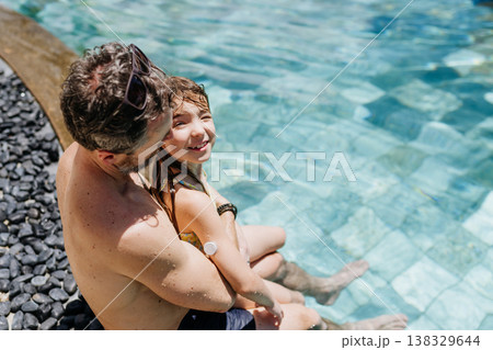 Family playing in tropical resort pool, child with diabetes wears glucose monitor. Family playing in tropical resort pool, child with diabetes wears glucose monitor. 138329644