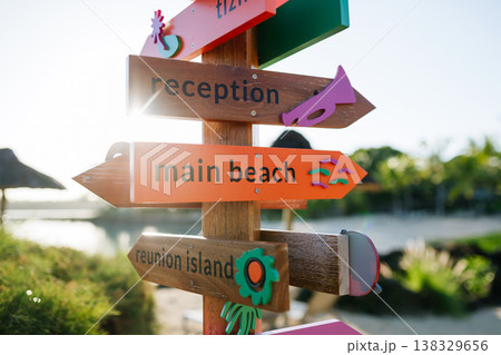Colorful wooden direction signs pointing to beach and reception in tropical resort. Colorful wooden direction signs pointing to beach and reception in tropical resort. 138329656