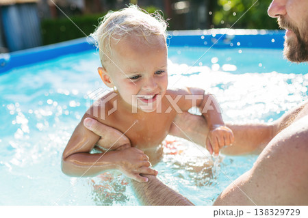 Father playing with little son in pool. Father playing with little son in pool. 138329729