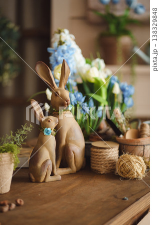 Decorative Easter bunnies with spring flowers and gardening tools 138329848