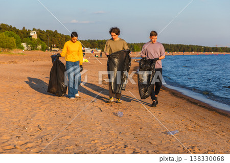 Earth day. Volunteers activists team collects garbage cleaning of beach coastal zone. Woman mans with trash in garbage bag on ocean shore. Environmental conservation coastal zone cleaning Earth day. Volunteers activists team collects garbage cleaning of beach coastal zone. Woman mans with trash in garbage bag on ocean shore. Environmental conservation coastal zone cleaning 138330068